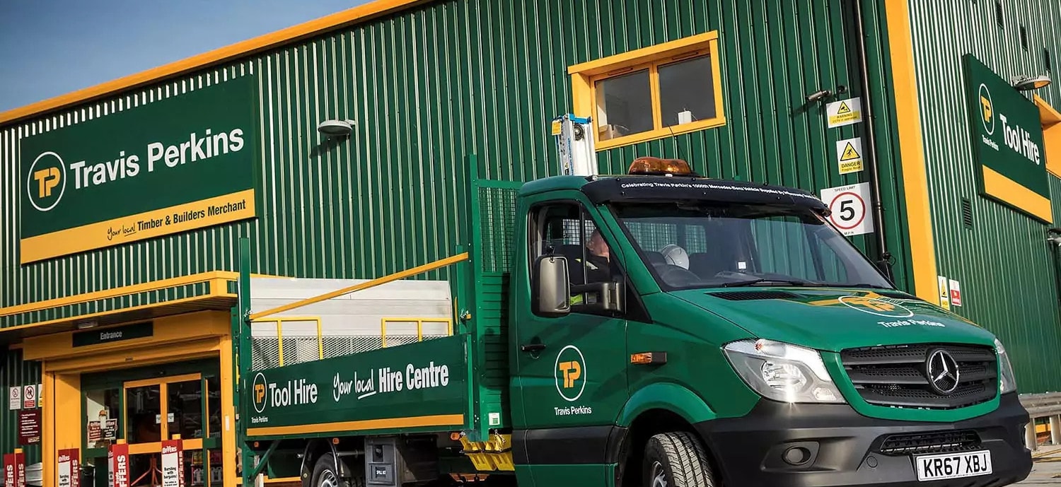 A Travis Perkins branch: the green-clad yard, its signage, and a Tool Hire truck out front.
